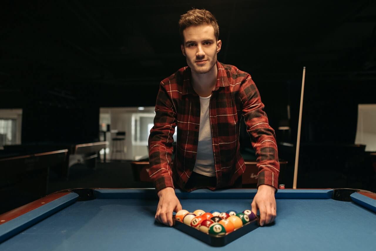 guy in shirt plays pool