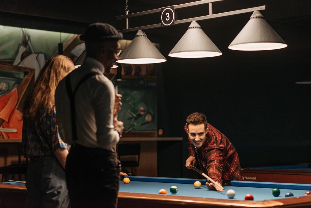 three people playing pool